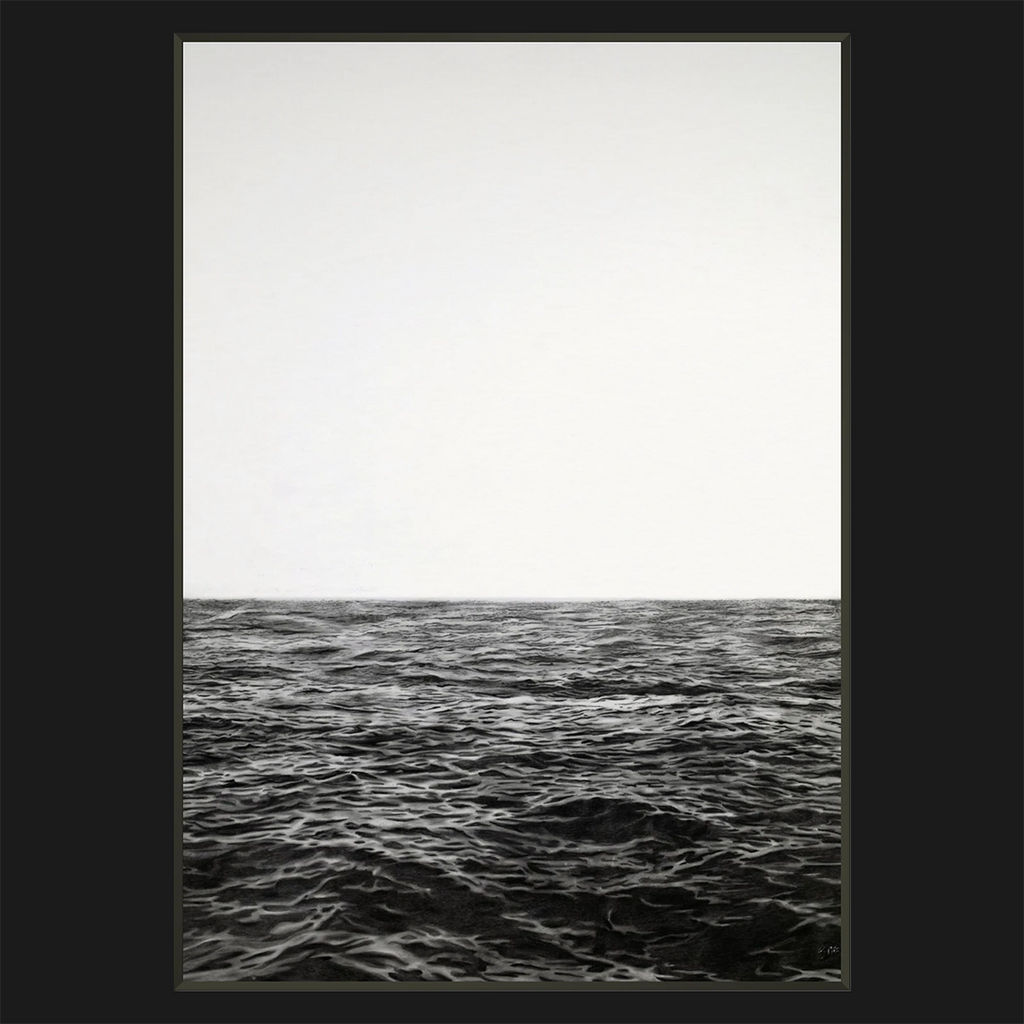 A framed minimalist black and white photorealistic drawing print depicting a calm ocean horizon under a pale, overcast sky, presented with a wide black border.